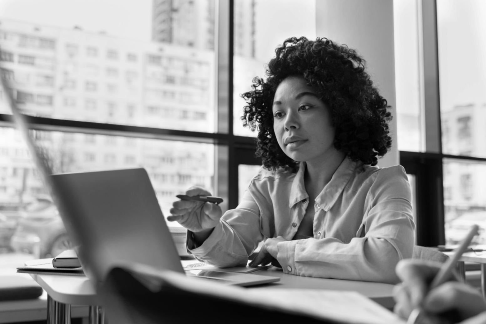 Profesional revisando estados financieros con documentos y laptop